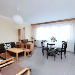 Przytulny salon z jadalnią, idealny na mieszkania do wynajęcia Płock. Duża kanapa, stół z krzesłami i stylowe meble.